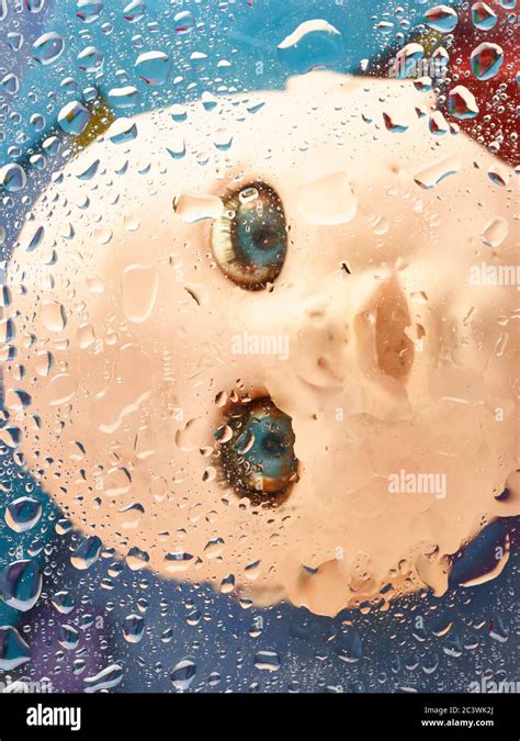 Severed dolls head drowning beneath colourful water droplets Stock ...