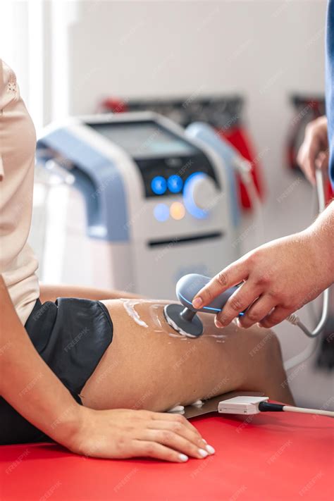 Premium Photo | Doctor using machine to treat the knee joints of a patient