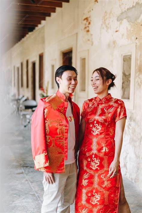 Happy young asian couple love in chinese traditional dresses - red is