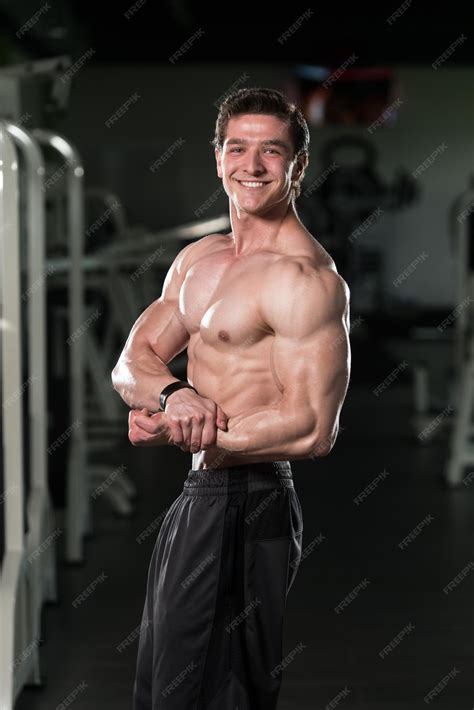 Joven culturista flexionando los músculos del lado del pecho pose