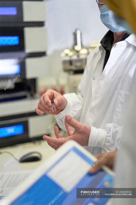 Scientists discussing sample in laboratory — indoors, Adults - Stock