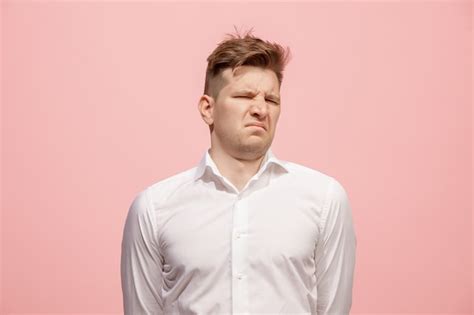 Молодой человек с отвращением выражает отвращение к чему-то ...
