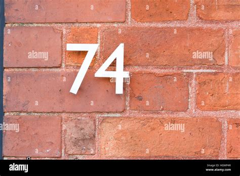 House Number 74 sign on red brick wall Stock Photo - Alamy