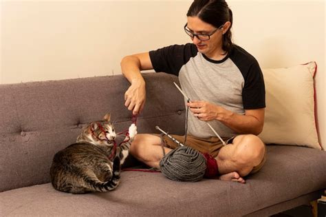 Premium Photo | Man playing with his cat on the sofa at home