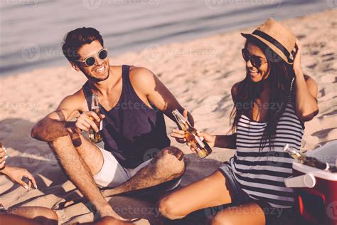 Beach party with friends. Cheerful young people spending nice time