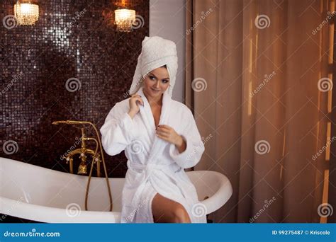Красивая молодая женщина в купальном халате и полотенце на голове ...