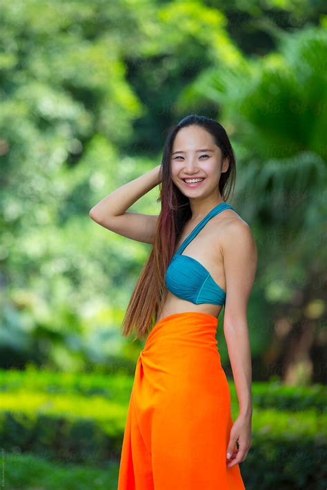 "Pretty Young Asian Or Chinese Woman Wearing Bikini In The Garden" by