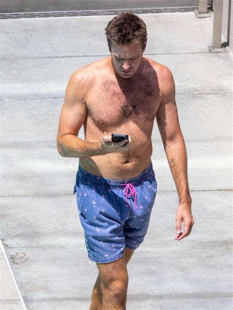 Armie Hammer goes shirtless & reveals new tattoo on rare outing before