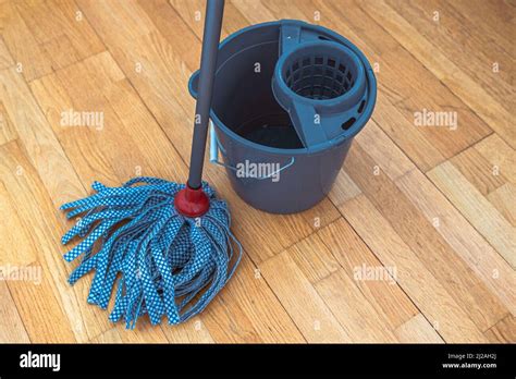Cleaning parquet floor with rope mop. Mop with tape nozzle and bucket ...