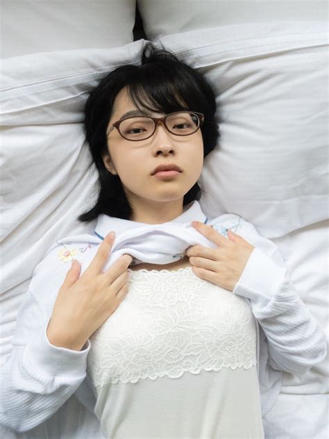 a woman laying in bed with her hands on her chest