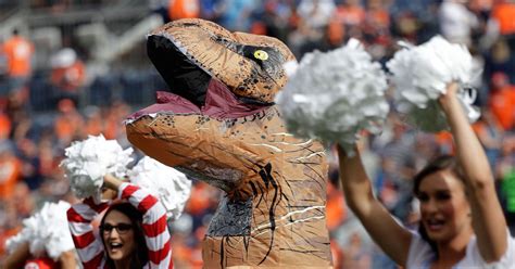 Broncos Cheerleader Romi Bean Wears Inflatable T-Rex Costume