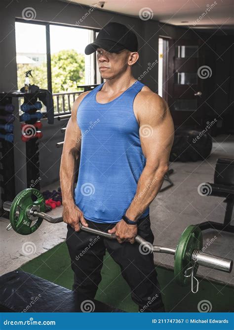 A Fit Asian Guy Does Upright Rows with an EZ Curl Bar at an Open Air