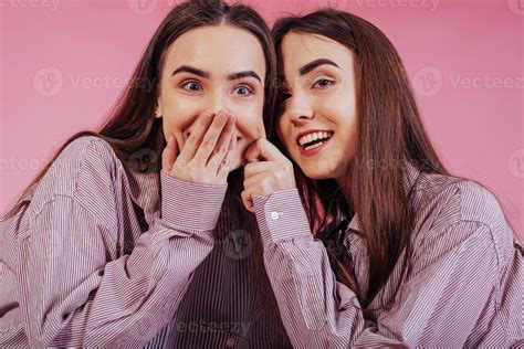 Playing and having fun with each other. Two sisters twins standing and