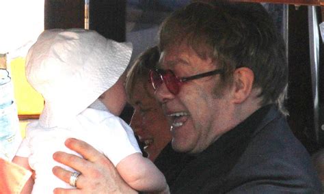 Sir Elton John keeps baby son Elijah entertained by pulling funny faces ...