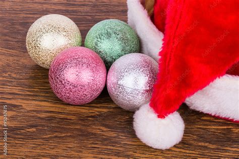 Новогодние игрушки и шапка на столе Photos | Adobe Stock