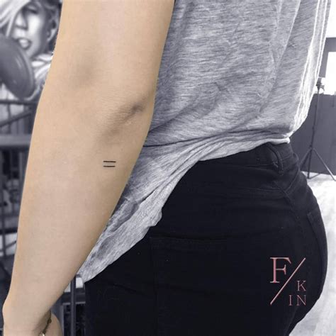 Equal sign tattoo on the left forearm.