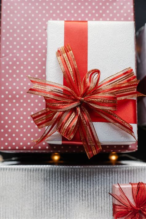 Present box with red ribbon on wrapped gifts · Free Stock Photo