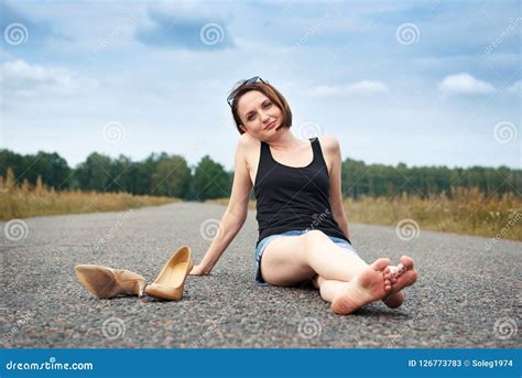 Young Girl Sitting Barefoot on the Road, she Left Her Shoes on the Road ...