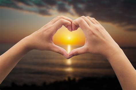 Premium Photo | Hands in shape of love heart at sunset