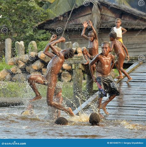 Kinder Des Stammes Von Asmat-Leuten Baden Und Schwimmen Im Fluss