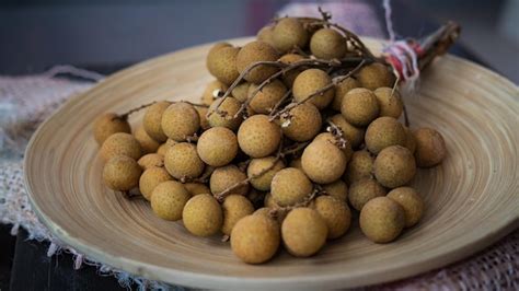 Premium Photo | Fresh longan or mata kucing on a wooden plate selected ...