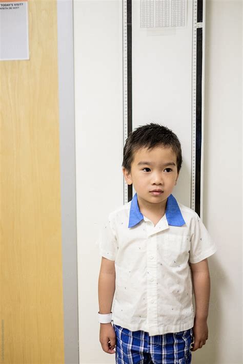 "Asian Boy Getting His Height Measured At The Doctor Office" by Stocksy