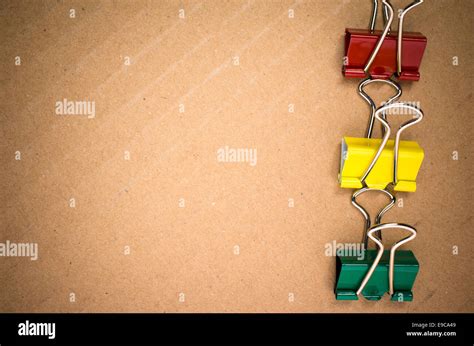 colored metal paper clips on a paperboard surface Stock Photo - Alamy