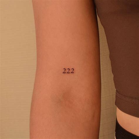 Angel number "222" tattoo located on the bicep.