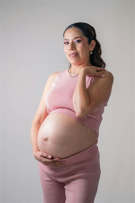 Pregnant Women Touching their Baby Bumps while Standing Next to Each