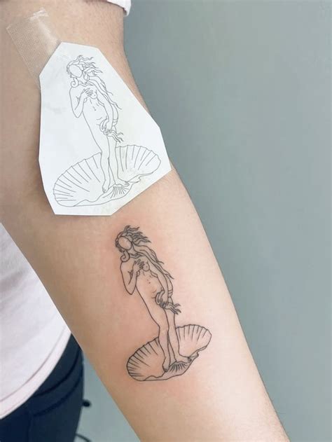 a woman with a mermaid tattoo on her arm