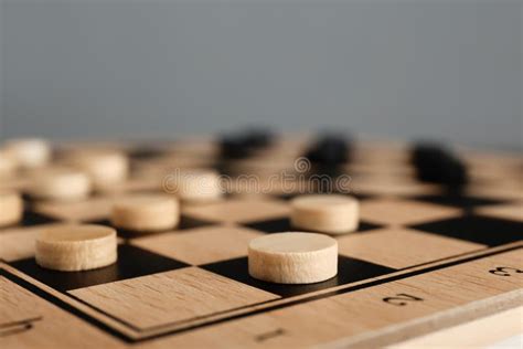 Wooden Checkerboard with Game Pieces on Light Grey Background, Closeup ...