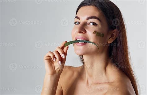 Naked woman is in the studio against white background with aloe vera