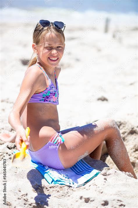 Little girl at tropical white beach making sand castle Stock Photo