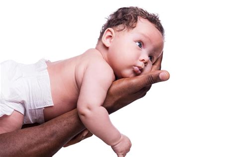 Cute baby. Side view of black hands holding cute little baby while isolated on white background ...