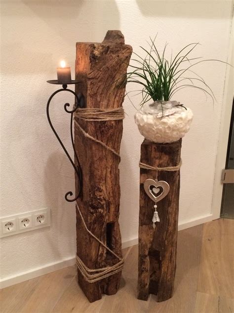 two wooden poles with plants in them on the floor next to a wall ...
