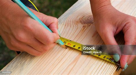 Woman Carpenter Makes Pencil Markings On A Wooden Board Diy In The ...