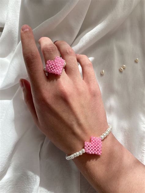 a woman's hand with two pink bracelets on it