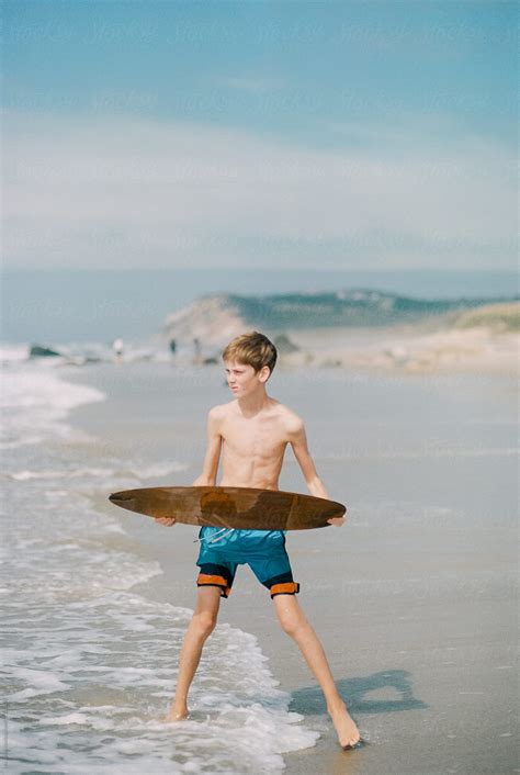 "Teen Boy With Skim Board At The Beach" by Stocksy Contributor "Lea