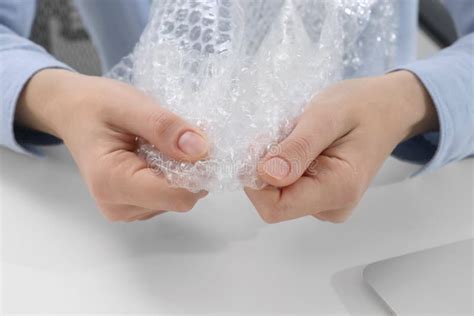 Woman Popping Bubble Wrap at Table in Office, Closeup. Stress Relief ...