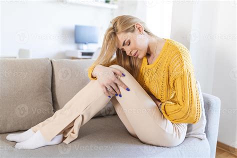 Woman in painful expression holding hands against belly suffering
