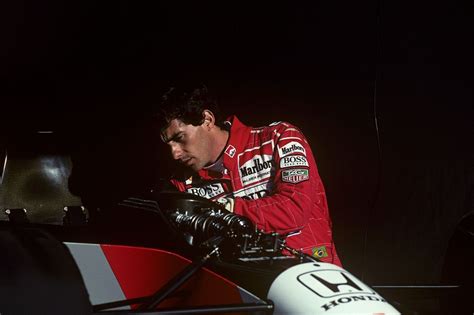 a man working on a racing car in the dark with his hand on the engine