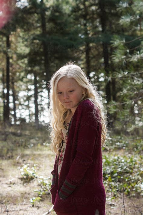 A Naked Woman Standing In The Woods With White Flowers Around Her Neck