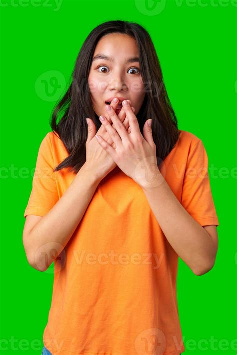 Surprised young woman expressing shock with hands over mouth against