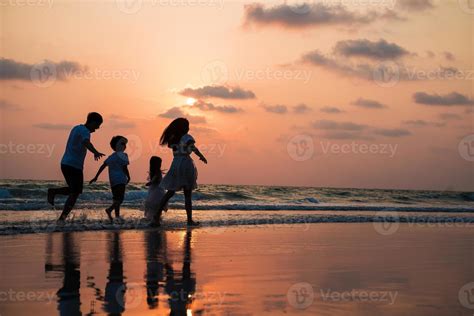 Silhouette family walking and playing at beach sunset with kids happy ...