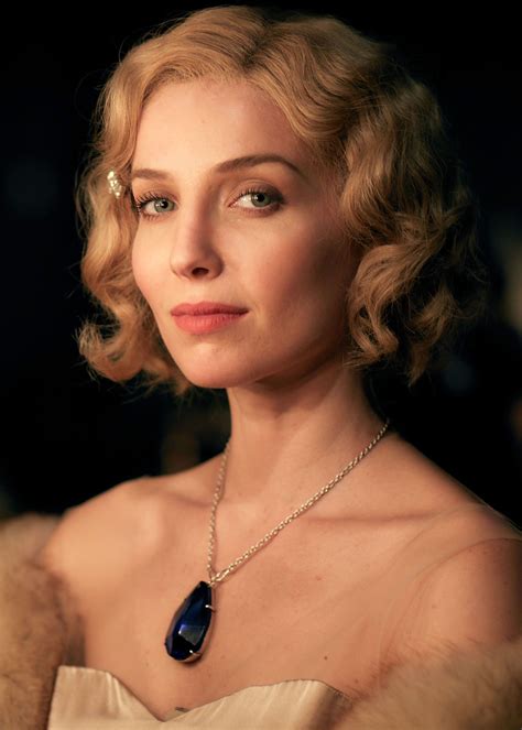 a woman with blonde hair wearing a necklace and fur stole around her ...