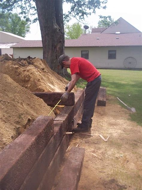 My husband building railroad tie retaining wall – Artofit