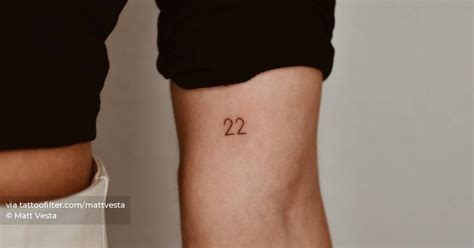 "22" lettering tattoo on the inner arm.