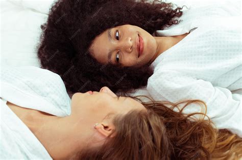 Premium Photo | Caucasian and black women love together and lying on ...