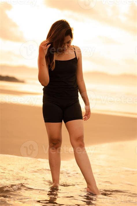 An Asian woman with blonde hair and a black dress hanging out lonely on