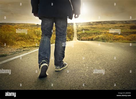 Lonely man walking on road Stock Photo - Alamy